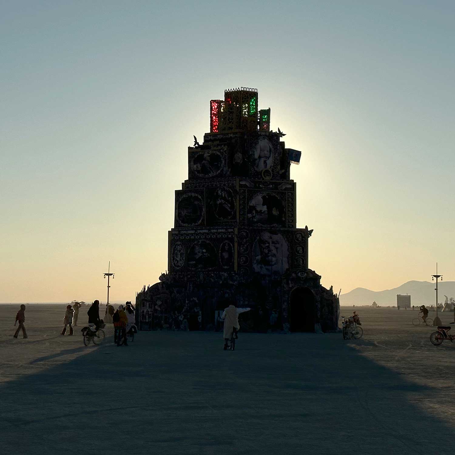 Tiered ornate tower sculpture silhouetted against golden sunset