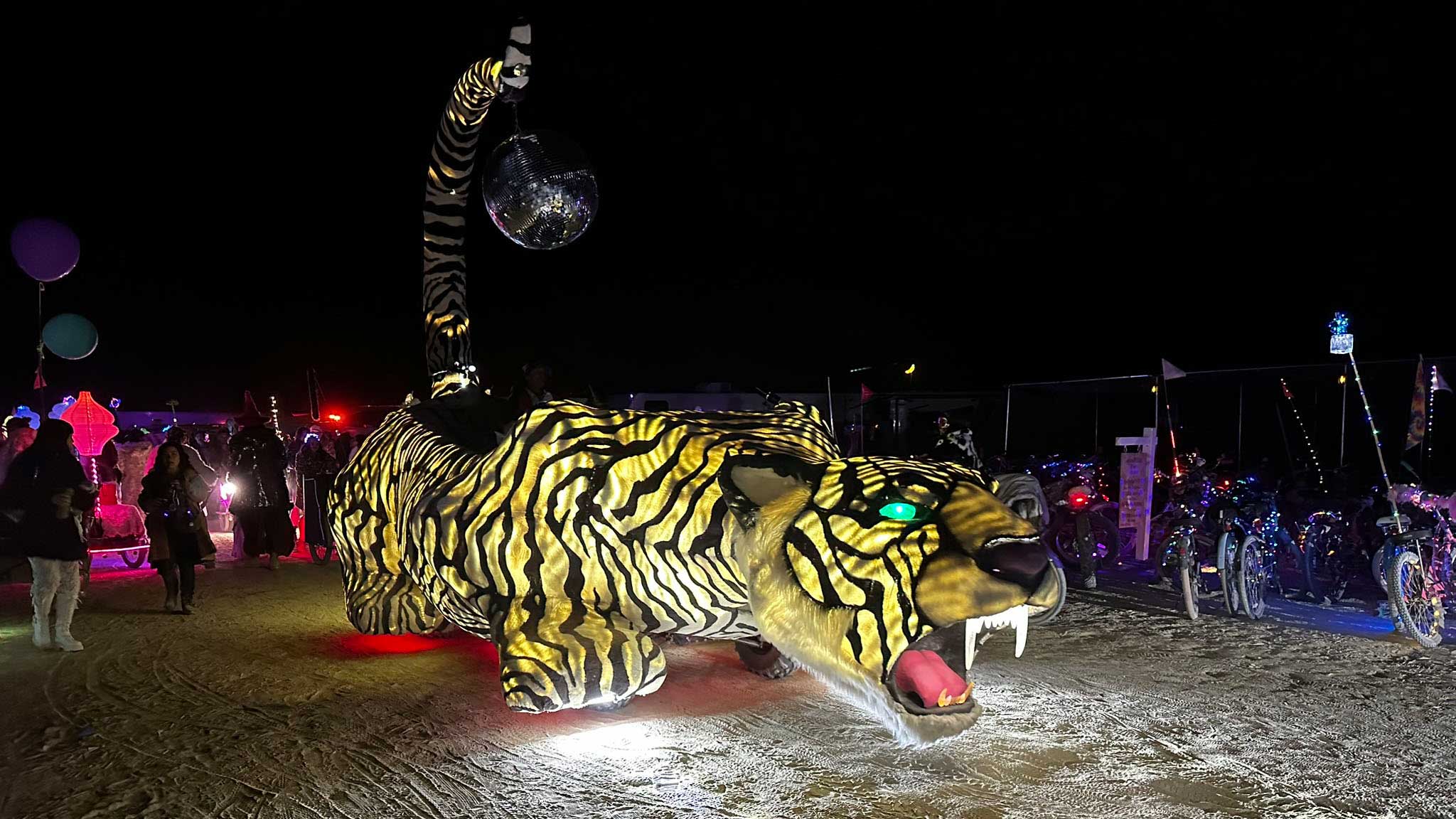 Tiger-striped art car with disco ball neck prowling the playa