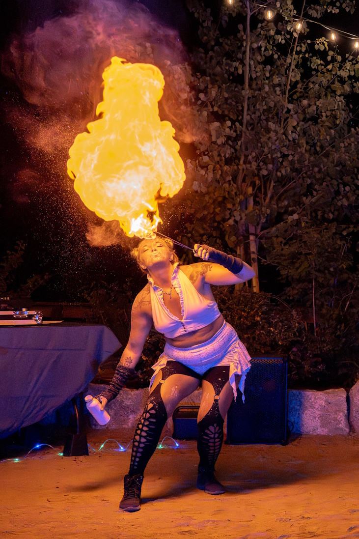 Fire breather producing massive fireball overhead at outdoor night event