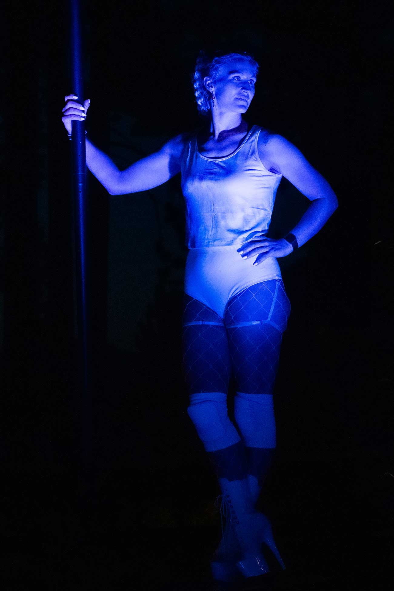 Female performer in blue leotard holding a pole