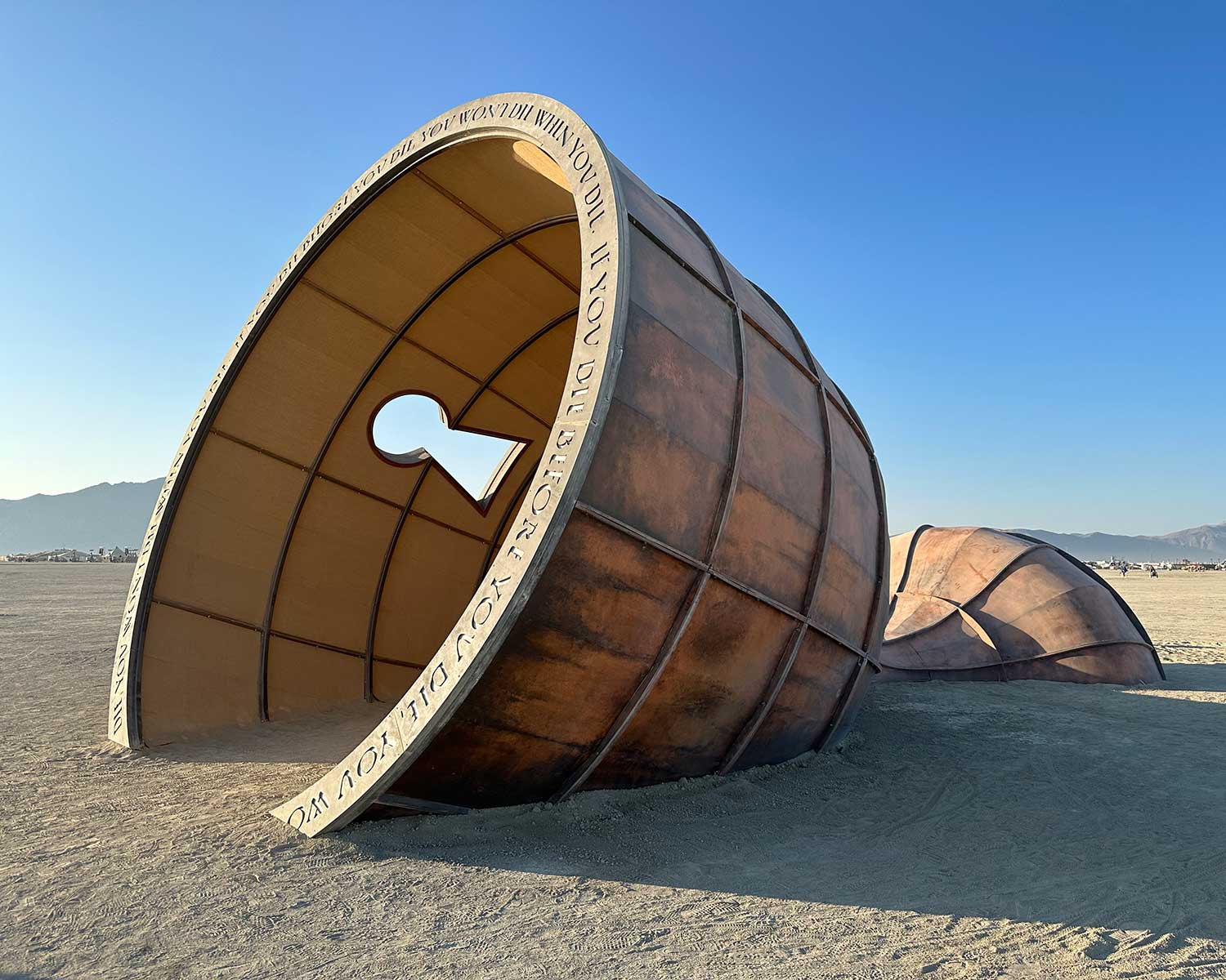 Large keyhole-shaped sculpture lying on Burning Man desert playa