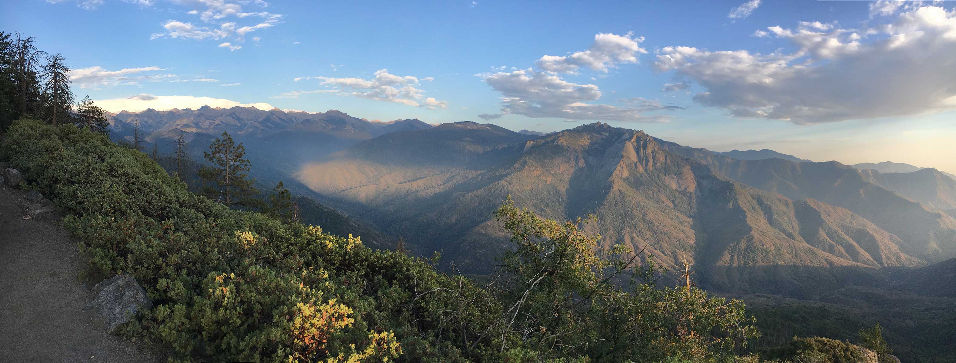 Panoramic hazy mountain ridges and deep canyon at sunset